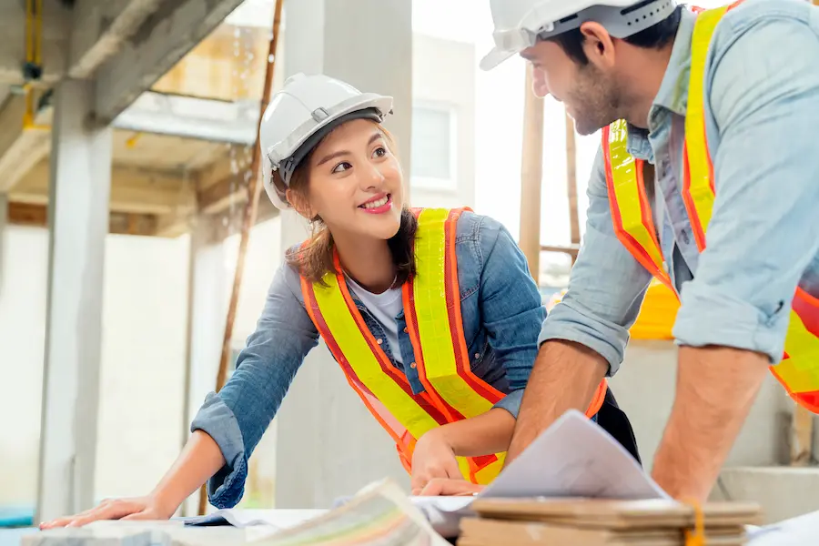 Young asian contractor smiling at her colleague