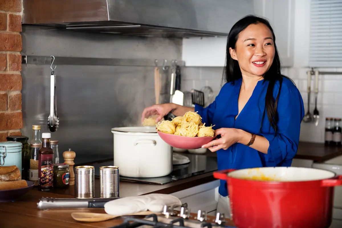 Asian woman smiling, preparing food in the kitchen