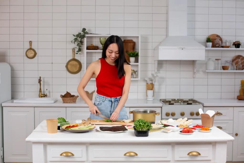 A woman in the kitchen is happily cutting vegetables